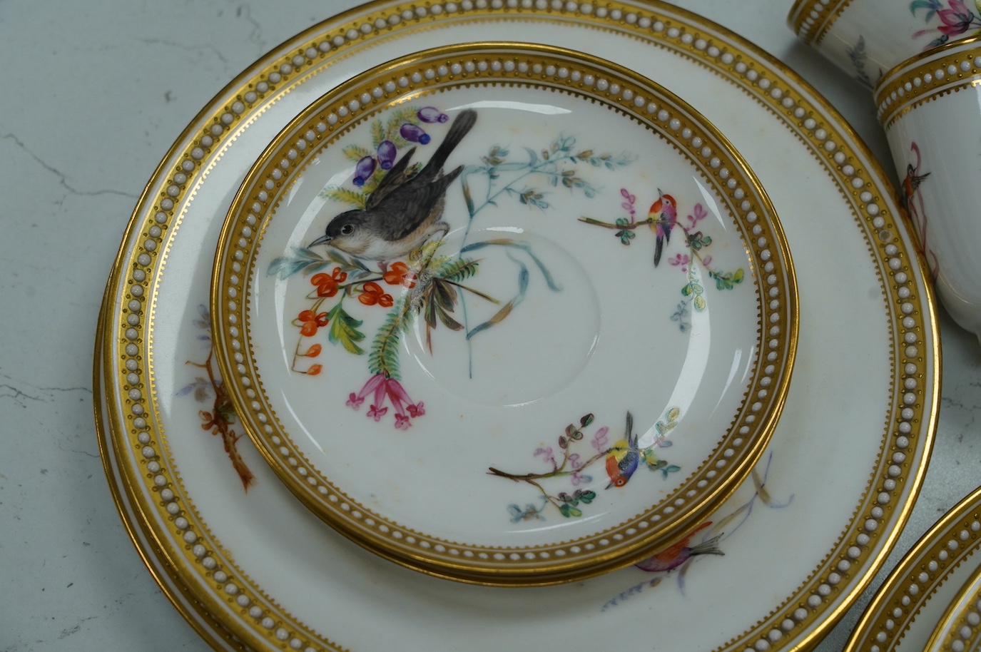 A 19th century Royal Worcester ornithologically decorated part tea set, with gilt and jewelled edges, six place setting. Condition - good